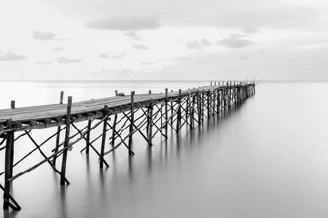 Black and white photography of a beach wooden pier